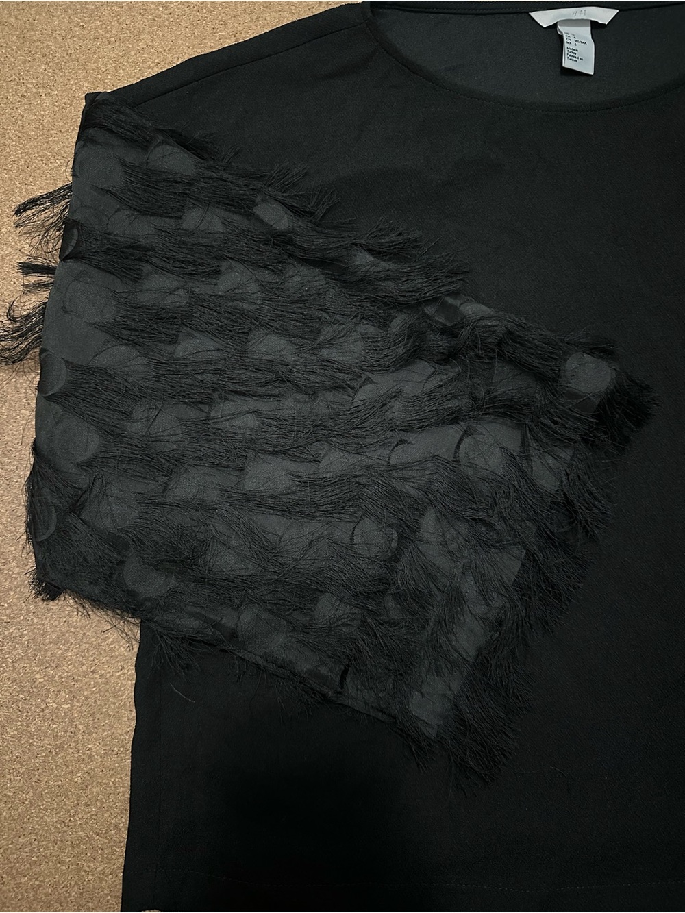 Black H&M top with feathered sleeves
